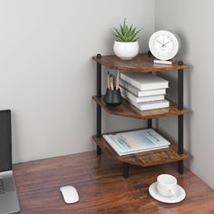 a laptop computer sitting on top of a wooden desk next to a stack of books