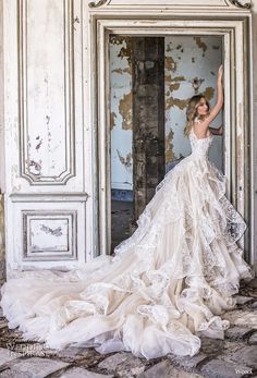 a woman in a wedding dress is standing by an open door and posing for the camera