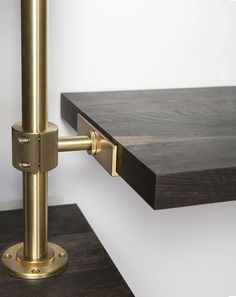 two wooden shelves with brass hardware on each side and one shelf mounted to the wall