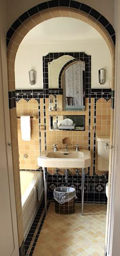 a bathroom with a sink, mirror and bathtub in the doorway to another room