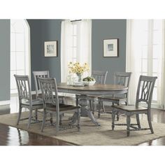 a dining room table with chairs and a rug in front of the table is shown