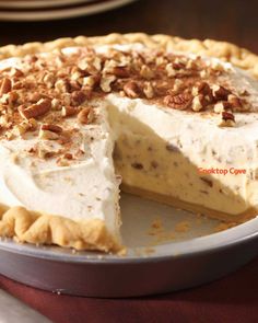 a pie with pecans on top sitting on a table