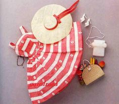 a red and white towel with a hat on top of it next to other items