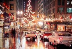 cars are parked on the street in front of christmas lights