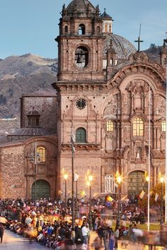 many people are gathered in front of an old building