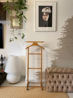 a living room filled with furniture next to a painting on the wall and potted plant