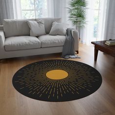 a living room with a white couch and a black rug that has yellow sunbursts on it