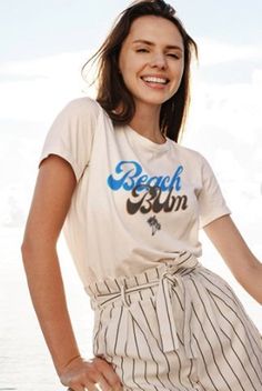 "The \"Beach Bum Shirt with Sun at the Bottom\" is not only visually appealing but also versatile in its styling options. Pair it with your favorite denim shorts or a flowy skirt for a laid-back beach-inspired look. Dress it up with a pair of linen trousers and sandals for a chic and casual evening out. The possibilities are endless, allowing you to express your personal style with ease. Whether you're strolling along the shoreline, enjoying a beachside bonfire, or simply soaking up the sun's rays, this shirt will make you feel like a true beach bum. It's a fantastic choice for beach lovers, summer enthusiasts, or anyone looking to add a touch of coastal charm to their wardrobe." Relaxed Short Sleeve T-shirt For Vacation, Casual Crew Neck T-shirt For Vacation, Casual Short Sleeve T-shirt For Beach Season, Casual Pre-shrunk T-shirt For Beach, Relaxed Crew Neck Summer Tops, Relaxed Crew Neck Tops For Summer, Beach Cotton T-shirt With Front Print, Relaxed Fit Cotton T-shirt For Vacation, Beachwear Tops With Short Sleeves For Day Out