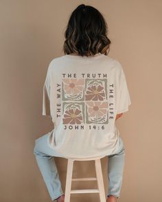 a woman sitting on a stool wearing a white t - shirt with the words, the truth