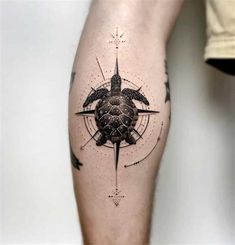 a man's leg with a turtle and compass tattoo on the side of his arm