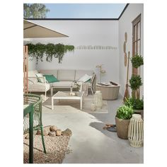 an outdoor living area with potted plants and furniture