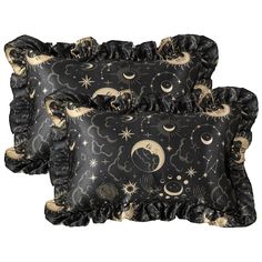 two black and gold pillows with stars, moon and crescents on them in front of a white background