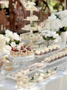 a table topped with lots of cupcakes and cakes