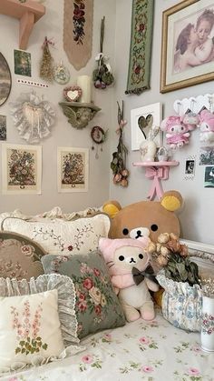 a teddy bear sitting on top of a bed in a room filled with pictures and other items