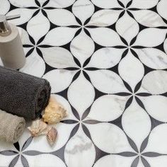 two towels are laying on the floor next to a roll of toilet paper and a toothbrush