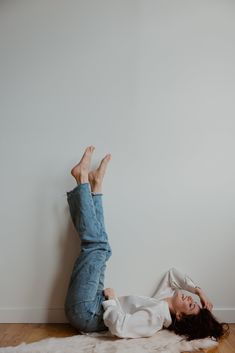 a woman laying on the floor with her legs up