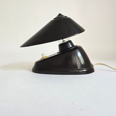 a black table lamp sitting on top of a white surface