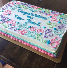 a birthday cake with congratulations written on the top and colorful swirls all over it