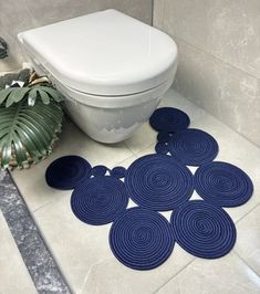 a bathroom with blue rugs on the floor next to a toilet