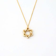 Crafted with exquisite attention to detail, our Star of David Charm Necklace in 14K Solid Gold is a timeless symbol of faith and heritage. This stylish Jewish Star necklace, a standout in our women's 14k yellow gold necklaces collection, features a captivating star of David charm. This dainty star necklace is an elegant, meaningful gift that perfectly combines spirituality and style. 14k solid gold handcrafted necklace 100% ethical sourced jewelry Material: 14k Solid Gold Pendant Height: 12 mm / Minimalist 14k Gold Star Of David Necklace, Fine Jewelry Star Of David Necklace For Formal Occasions, Formal Star Of David Fine Jewelry Necklace, Classic Star Of David Jewelry For Anniversary, Classic Star Of David Jewelry For Gift, Minimalist Gold Necklace With Star Of David, Elegant Star Of David Necklace, Minimalist Yellow Gold Star Of David Necklace, Elegant Star Of David Jewelry For Formal Occasions