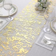 the table is set with silver and gold place settings