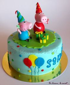 there is a birthday cake with two pepo pigs sitting on top of the cake