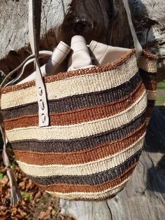 These individually woven colourful bags were woven by women in certain regions of Kenya https://en.wikipedia.org/wiki/Kiondo. The weaving skills were handed down from mothers and grandmothers. This bag has interwoven colours of shades of brown and beige. This bag is unique and is the only one of it's kind in the world. Natural Woven Pouch Shoulder Bag, Natural Color Woven Pouch Bag, Brown Woven Leather Basket Bag, Natural Leather Woven Bucket Bag, Woven Leather Basket Shoulder Bag, Brown Woven Straw Shoulder Bag, Natural Woven Satchel Shoulder Bag, Handwoven Leather Bucket Bag In Natural Color, Woven Leather Basket Bag