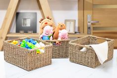 two stuffed animals sitting in baskets on top of a table