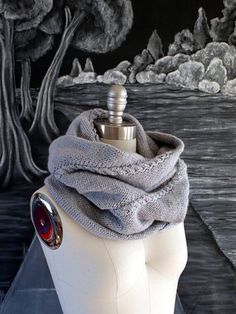 a white mannequin with a gray scarf on it