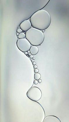 an abstract painting with water and bubbles in the shape of pebbles on a white background