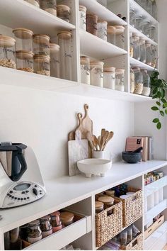 a kitchen with lots of shelves filled with different types of items and utensils