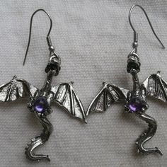 This Is A Set Of Dragon Earrings With French Style Earwires. Made Of Pewter, Each Dragon Holds A Round Purple Set. Open Wings. 3d: Has Full Back Side Of Dragon. Made In Usa By Real Metal. Each Dragon Is 1 3/4 Inches Long And 1 1/2 Inches Wide. Total Length With Earwire Is 2 1/4 Inches. Lovely Detail. Great For Dragon Fans And Fantasy Lovers. Handmade Fantasy Metal Earrings, Handmade Metal Fantasy Earrings, Fantasy Metal Earrings For Jewelry Making, Fantasy Metal Earrings For Gift, Fantasy Style Metal Earrings For Gift, Fantasy Metal Earrings With Ear Wire, Adjustable Fantasy Earrings For Gifts, Adjustable Fantasy Earrings For Gift, Nickel-free Fantasy Drop Earrings