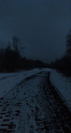 the road is covered in snow at night