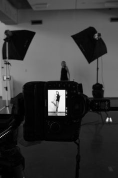 black and white photograph of a woman dancing in front of several camera's on a tripod