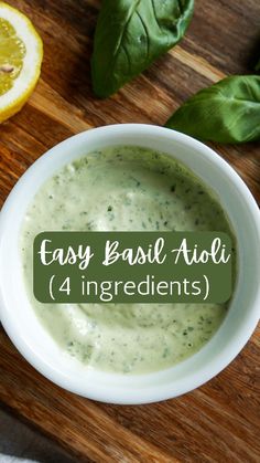 a white bowl filled with pesto sauce next to sliced lemons and basil leaves