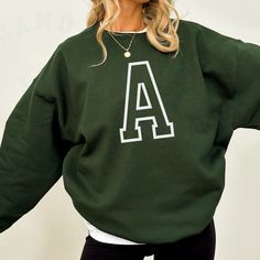 Introducing the Gildan College Block Letter Custom Sweatshirt, where style meets personalization in the coziest form. Crafted from the finest materials, this sweatshirt embodies comfort and individuality. The front of the sweatshirt proudly features a classic College Block Letter design, showcasing a custom letter of your choice. Whether it's your initial, a meaningful symbol, or a representation of your alma mater, this personalized touch adds a unique and distinctive flair to your wardrobe. Made from high-quality Gildan fabric, this sweatshirt ensures a soft and snug fit that's perfect for everyday wear. The attention to detail in the College Block Letter outline adds a timeless and collegiate aesthetic, making it a versatile addition to your casual attire. Whether you're heading to clas Collegiate Aesthetic, Campus Style, Letter Sweatshirt, Outfit Chic, Unisex Gift, Letter Design, Alma Mater, Custom Sweatshirts, Custom Letters