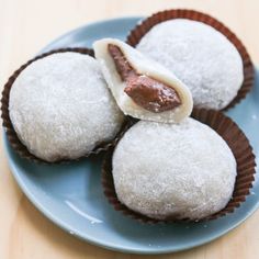 three pastries on a blue plate covered in powdered sugar