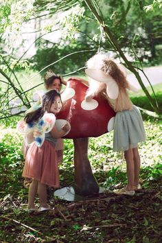 three girls standing in front of a mushroom with the words meri meri on it