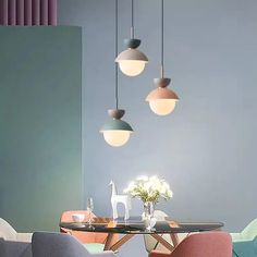 an image of a dining room setting with modern lighting fixtures hanging above the table and chairs