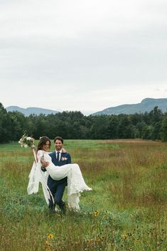 a bride carries her groom across the field