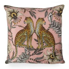 a pink pillow with two cheetah on the front and green leaves in the back