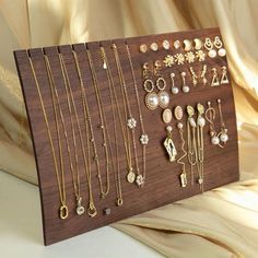 a wooden display with many different types of jewelry on it