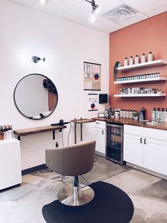 a salon with white cabinets and brown hair dryer on the counter, mirror above it