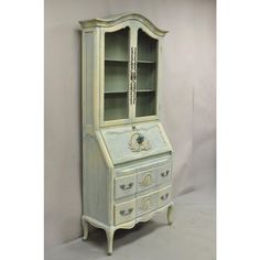 an old fashioned dresser with glass doors and drawers on the top, painted in white