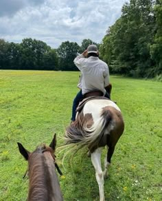 a man riding on the back of a brown and white horse