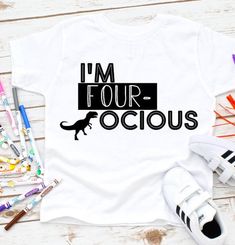 i'm four oclous t - shirt on a table with markers and pens