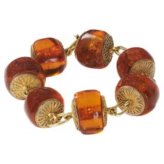 An antique amber and gold bracelet, with large amber beads, with gold discs either side, decorated with Etruscan style wirework, with single oval gold links, in a Richard A. Green fitted case, with gold M. A. S. initials, in gothic script, circa 1875. Richard Angell Green traded from 82 Strand, WC. He was elected as a member of the Society for the Encouragement of Arts, Manufacturers and Commerce in 1859. His address appears in the 1862 Post Office directory. He applied for a patent for the design or production of earrings, on 31st December, 1870. He sold jewellery of classical design. Condition: Good, with some crazing to the amber Gold Oval Bohemian Bracelets, Bohemian Gold Oval Bracelets, Vintage Gold Beaded Bracelets For Gift, Gothic Script, Antique Bracelets, Gold Armband, Gold Disc, Amber Beads, Amber Jewelry