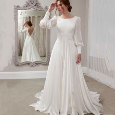 a woman in a wedding dress looking at herself in the mirror