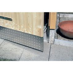 an image of a door that is open on the side of the street with a bowl next to it