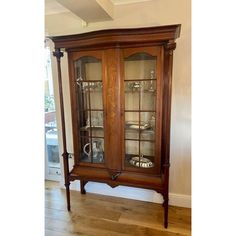 an old fashioned china cabinet with glass doors